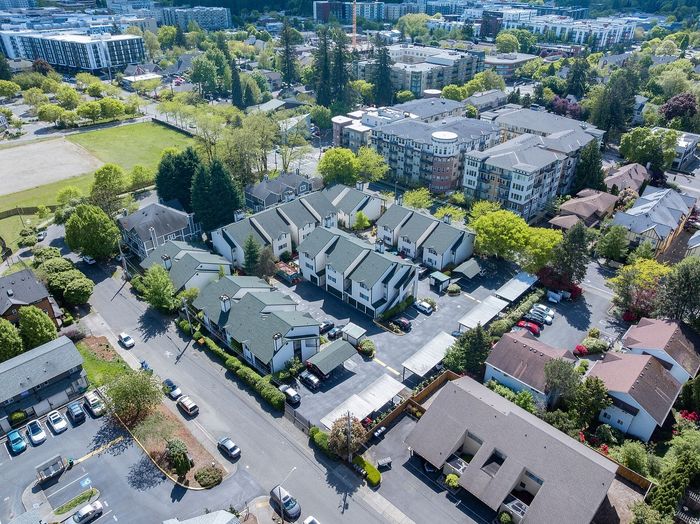Aerial view of a vibrant apartment complex surrounded by lush greenery, nestled in a thriving urban neighborhood.