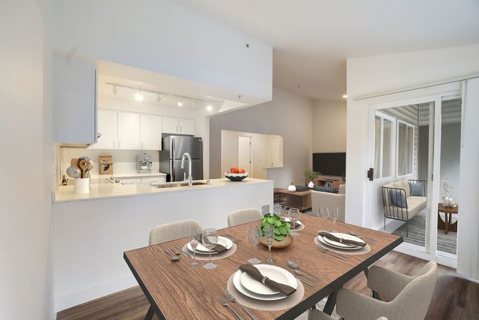 Modern open-concept kitchen and dining area with elegant decor, featuring sleek appliances and a cozy living space.