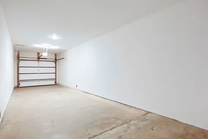Spacious attached private garage with automatic door opener and concrete floor at Garrett Harvest Junction West apartments in Longmont, CO