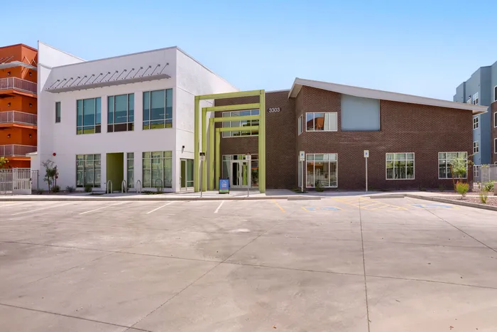 Garrett Uptown leasing office exterior with brick facade and green architectural portal in Chandler, AZ