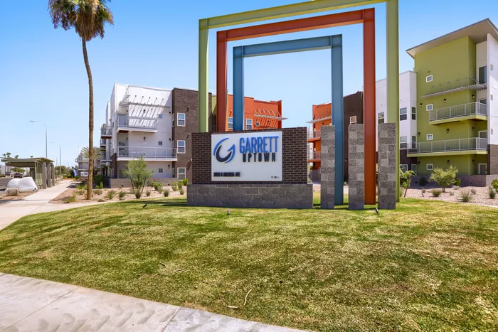Garrett Uptown monument sign with colorful stacked-frame public art at apartment community in Chandler, AZ