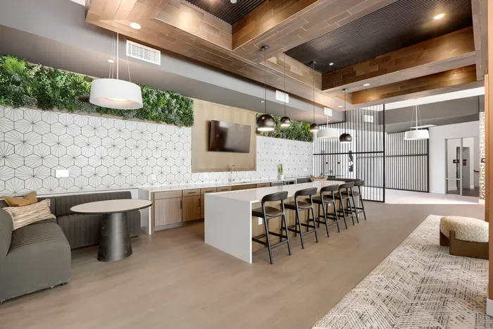Garrett Uptown clubhouse bar and lounge with white quartz island, bar seating, living wall, and geometric tile accent in Chandler, AZ