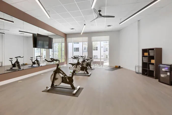 Garrett Uptown spin cycle studio with SILK indoor cycling bikes, floor-to-ceiling mirrors, ceiling fan, and natural light in Chandler, AZ