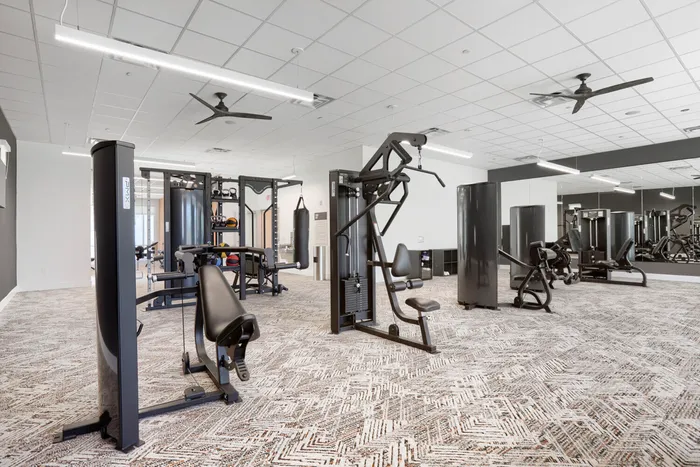 Garrett Uptown fitness center with cable machines, functional trainer, punching bag, and mirrored walls in Chandler, AZ