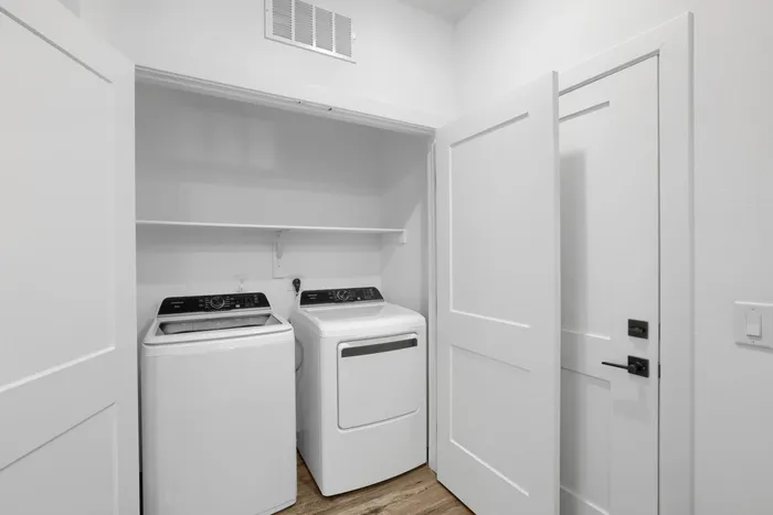 Garrett Uptown B2 apartment in-unit full-size washer and dryer in dedicated laundry closet with shelving in Chandler, AZ