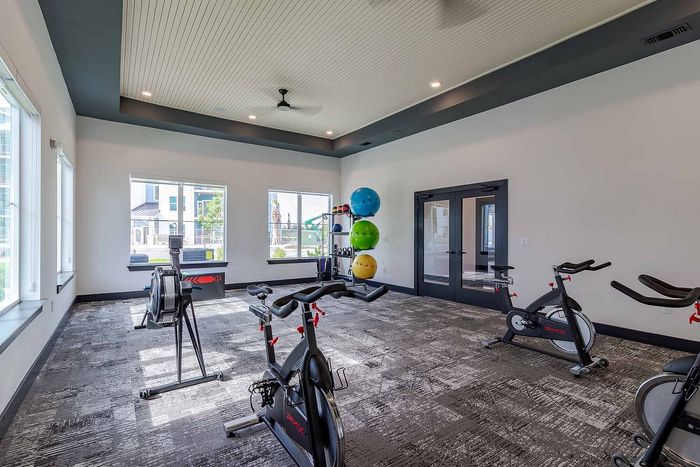 Fitness center with spin bikes, rowing machine, and stability balls at Garrett Gateway apartments in Fort Myers, FL