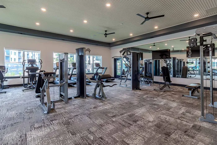 Fitness center with strength training machines, cardio equipment, and mirrored wall at Garrett Gateway in Fort Myers, FL