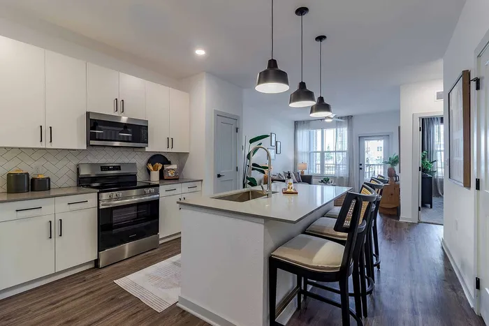 A1 floor plan kitchen with quartz island, stainless appliances, and pendant lighting at Garrett Gateway in Fort Myers, FL