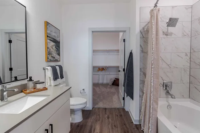 A1 floor plan bathroom with marble-style tub surround, dual access, and walk-in closet at Garrett Gateway in Fort Myers, FL