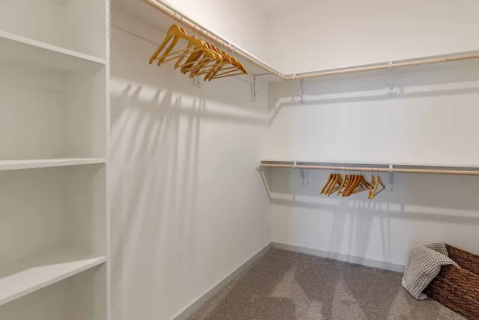 Spacious walk-in closet with built-in shelving and double hanging rods at Garrett Gateway apartments in Fort Myers, FL