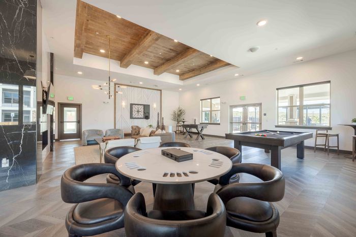 Game table and lounge chairs in the Garrett Parker clubhouse game room