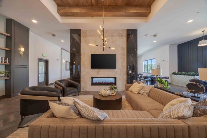 Fireplace lounge seating area in the Garrett Parker apartments clubhouse