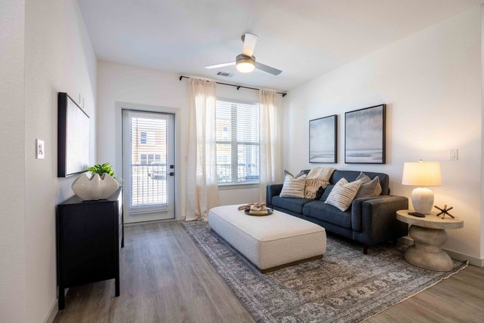 Living room with sofa and patio access in the Garrett Parker B1 floor plan
