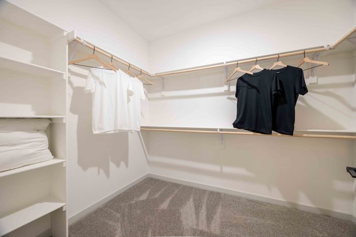 Walk-in closet with shelving in the Garrett Parker B1 floor plan primary bedroom