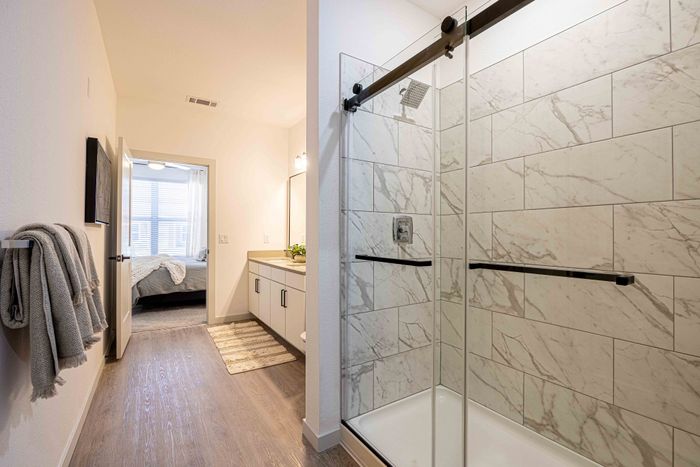 Walk-in shower with marble tile in the Garrett Parker B1 floor plan primary bathroom