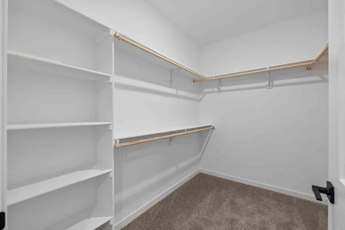 Walk-in closet in the A1 one-bedroom at Garrett Fillmore with built-in shelving and double hanging rods.