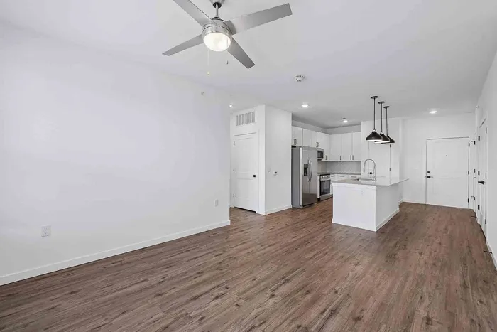 Living room in the B1 two-bedroom at Garrett Fillmore with a ceiling fan, blinds, and a private balcony door.
