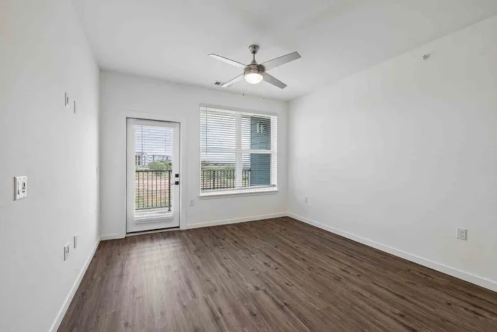 Open-concept living room and kitchen in the B1 two-bedroom at Garrett Fillmore with a ceiling fan and vinyl plank flooring.