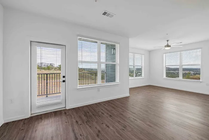 Open dining and living area in the C1 three-bedroom at Garrett Fillmore with corner windows and balcony door access.