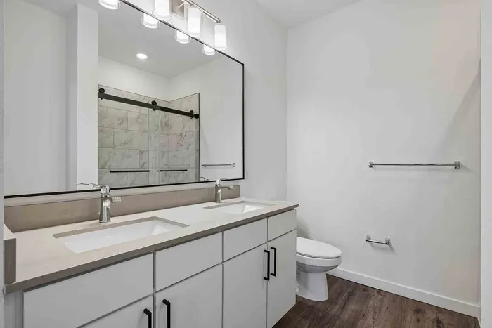 Primary bathroom in the C1 three-bedroom at Garrett Fillmore with a double sink vanity and a full-width mirror.