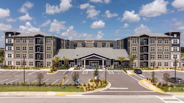 Aerial view of Garrett Forum apartments in Fort Myers, Florida, showing the leasing office and four-story residential buildings.