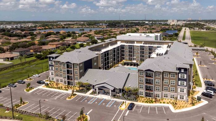 Aerial view of the Garrett Forum leasing office and surrounding apartment buildings, with the courtyard pool visible between them