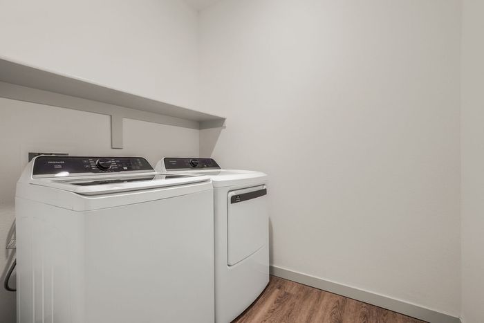 Laundry room in a C1 three-bedroom at Garrett North Powers with a white washer and dryer and an overhead shelf