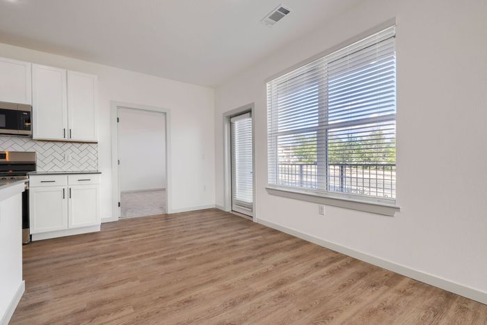 Dining area beside the kitchen in a C1 three-bedroom at Garrett North Powers with a large window and patio door