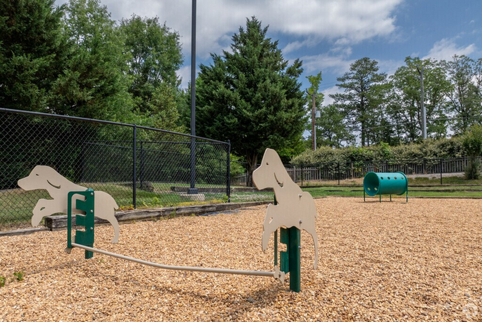 Charming pet park with playful dog obstacles set in a lush, green outdoor space.