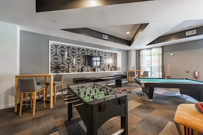 Chic recreational room featuring a foosball table, pool table, and modern decor, perfect for leisure and entertainment.