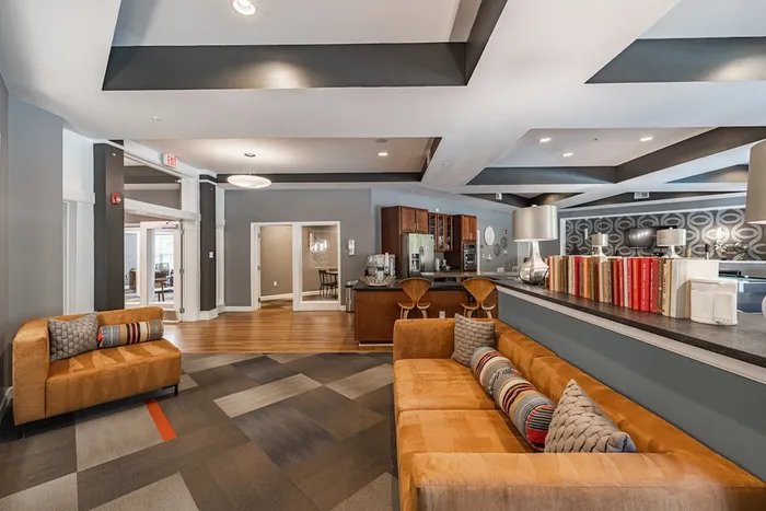 Chic modern lounge with cozy seating, stylish decor, and a sleek kitchen area.