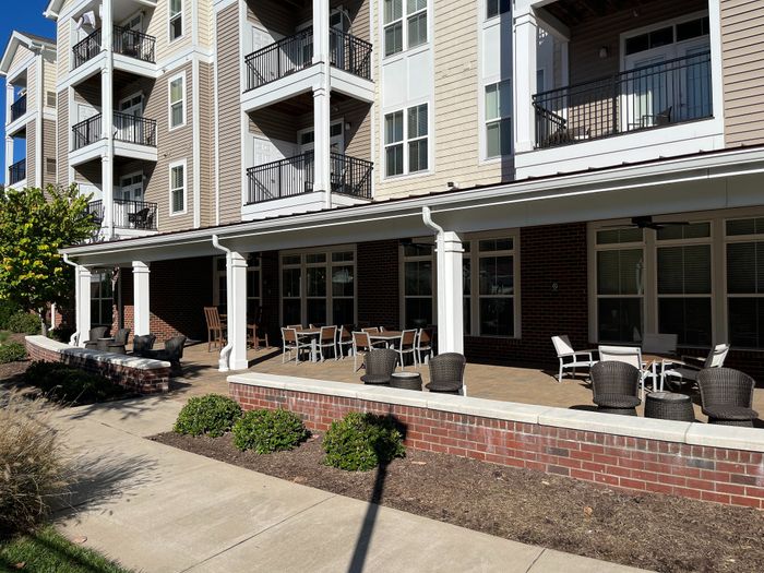 Elegant apartment building with spacious balconies and a vibrant outdoor seating area, perfect for relaxation and socializing.