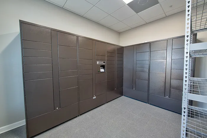 Modern package locker room with sleek, secure lockers and metal shelving, offering convenient storage solutions.