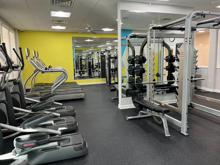 Bright, modern gym with cutting-edge fitness equipment including treadmills, weight racks, and a spacious workout area.