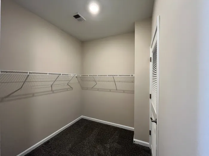 Spacious walk-in closet with ample shelving in a modern apartment, perfect for organized storage.