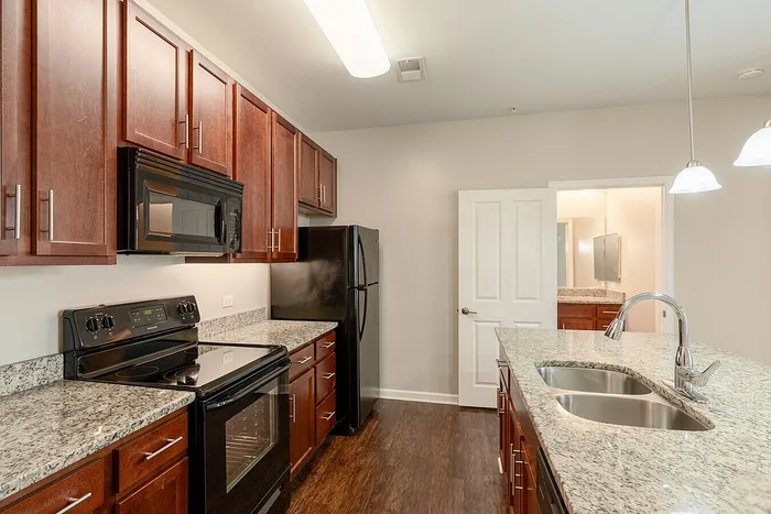Modern kitchen with elegant granite countertops, sleek stainless-steel sink, and stylish wooden cabinets.