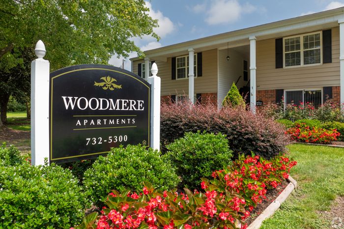 Inviting exterior of Woodmere Apartments showcasing lush landscaping and a welcoming entrance, perfect for tranquil living.