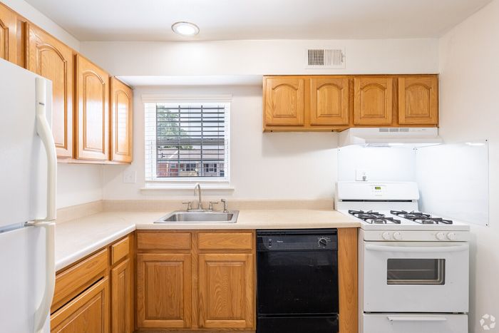 Bright kitchen with classic wooden cabinets, modern appliances, and a large window for natural light.