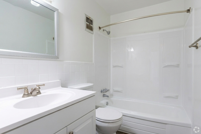 Bright and modern bathroom with sleek white fixtures, a polished vanity, and a spacious bathtub ready to offer a relaxing retreat.