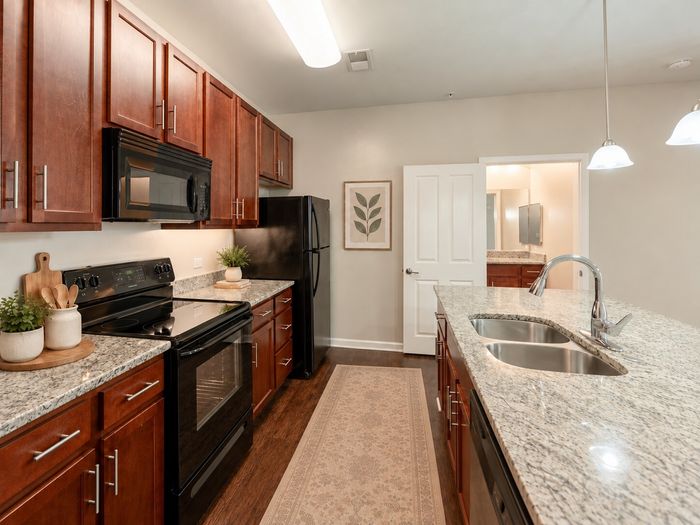Modern kitchen with elegant granite countertops, sleek appliances, and stylish wooden cabinetry.