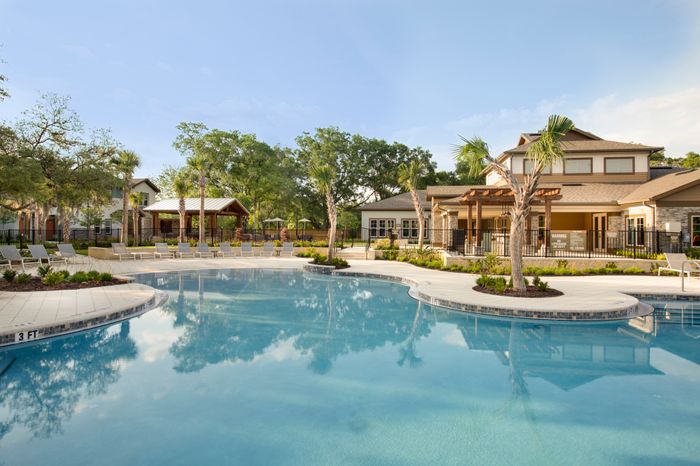 Photo of community pool with outdoor seating.