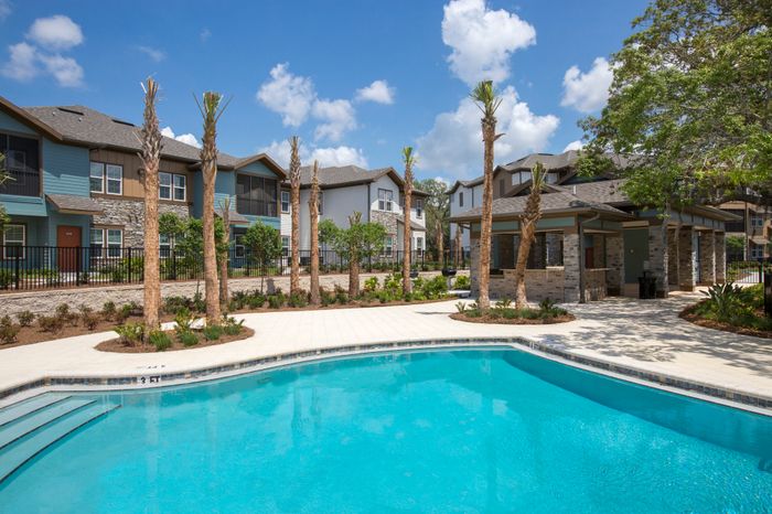 Photo of community pool with outdoor seating.