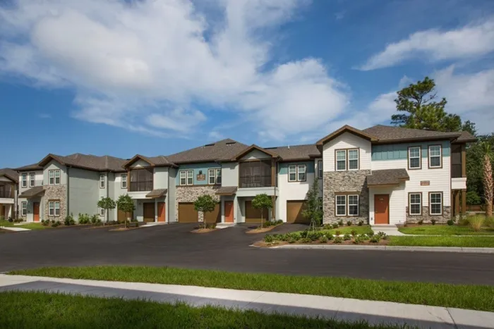 Photo of 2-story apartment building with built-in garages an screened balconies.