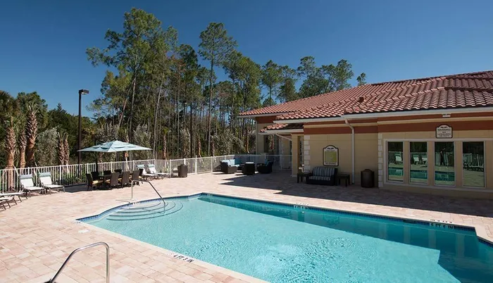 Serene swimming pool and building Sandalwood Village | Naples FL