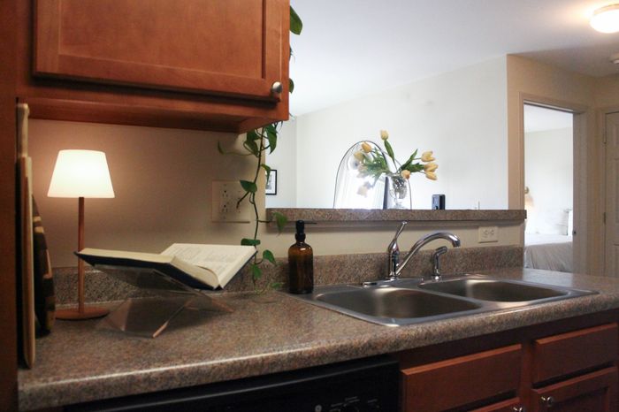 Cozy kitchen nook with elegant granite countertops, a chic double sink, and ambient lighting, providing a warm and inviting atmosphere.