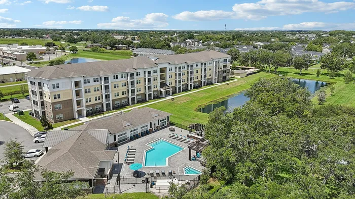 Charming apartment complex with a refreshing pool, nestled in lush greenery and serene surroundings.