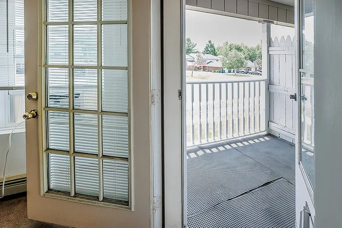 Inviting balcony view with elegant glass door, perfect for relaxing and enjoying the neighborhood scenery.