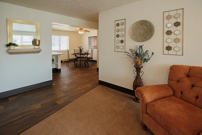 Inviting open-concept living space showcasing a cozy seating area, elegant hardwood floors, and a stylish dining nook with natural light.