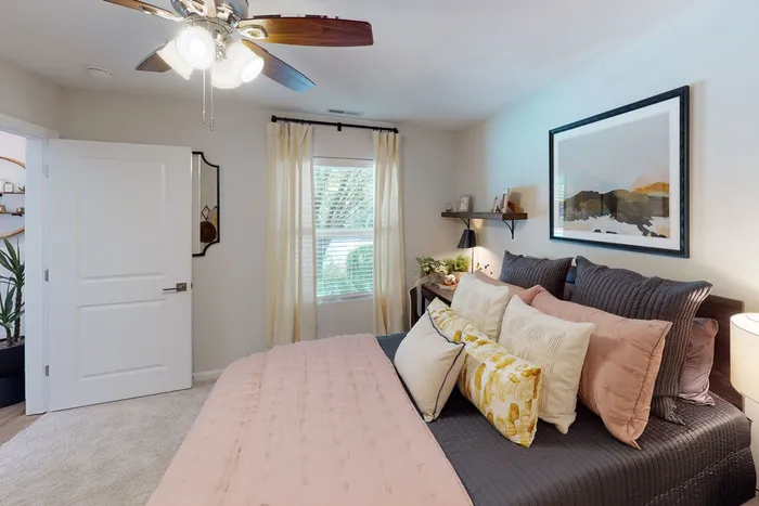 Bright bedroom with soft natural light, neutral walls, and a ceiling fan at The Preserve Murfreesboro.