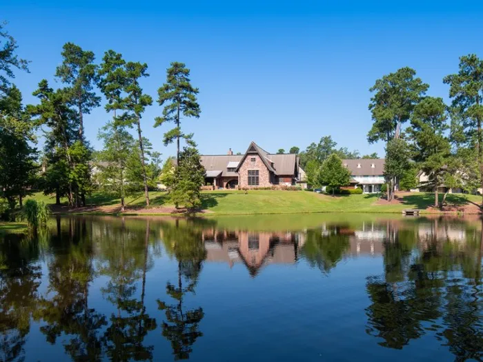 Peaceful lakeside view of The Cottages of Hattiesburg, showcasing the community’s scenic greenery and charming architecture, perfect for relaxing and enjoying nature.